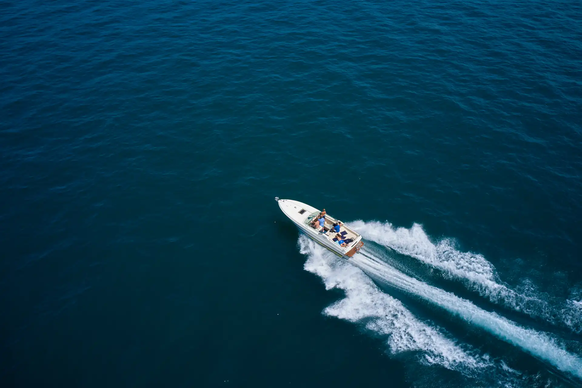 A speed boat cutting through open water with Seajet yellow splash visual